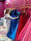 Pageant contestant looking at couture gowns in exclusive pageant showroom.